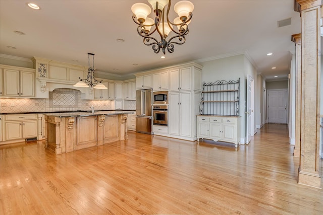 kitchen featuring appliances with stainless steel finishes, cream cabinets, backsplash, a chandelier, and a kitchen bar