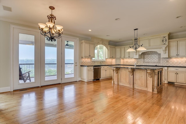kitchen with cream cabinetry, dishwasher, a chandelier, light wood-style flooring, and ornamental molding