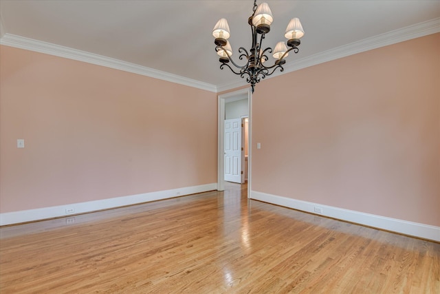 unfurnished room featuring a chandelier, baseboards, light wood-style flooring, and ornamental molding