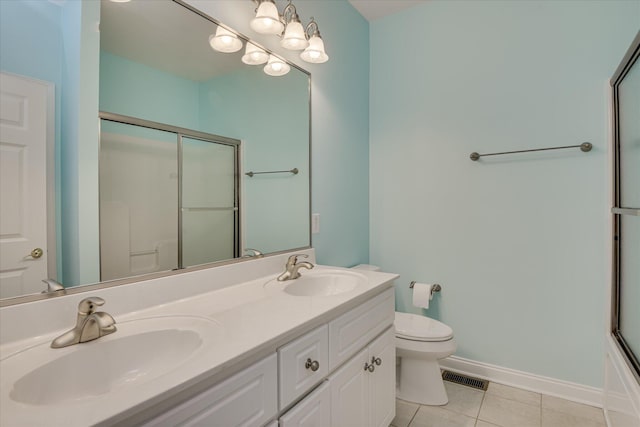 full bath with tile patterned floors, a shower with shower door, toilet, double vanity, and baseboards