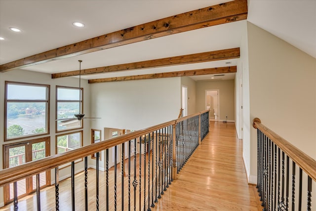 corridor featuring recessed lighting, light wood finished floors, baseboards, an upstairs landing, and beam ceiling
