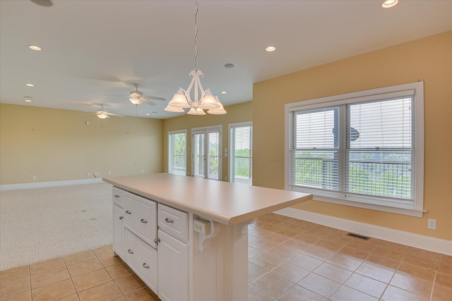 kitchen with light tile patterned flooring, white cabinetry, recessed lighting, decorative light fixtures, and baseboards