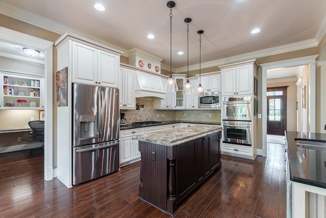 3820 Blue Springs Trce, Evans, GA 30809 - kitchen featuring appliances with stainless steel finishes, dark stone countertops, premium range hood, decorative light fixtures, and dark wood finished floors