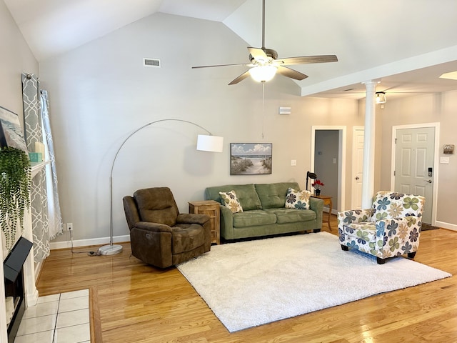 living area featuring ceiling fan, high vaulted ceiling, light wood-style flooring, visible vents, and ornate columns