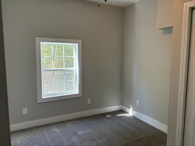 empty room with dark carpet and ceiling fan