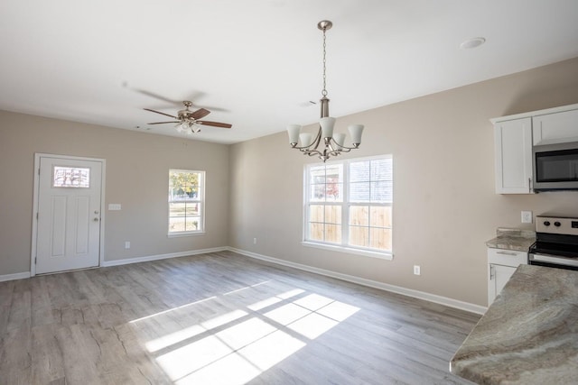 kitchen featuring white cabinets, a wealth of natural light, stainless steel appliances, and pendant lighting