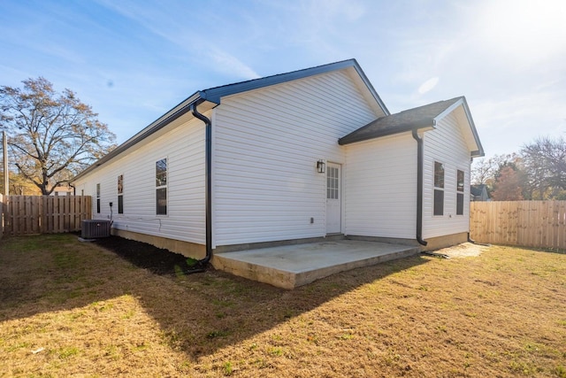 back of property featuring cooling unit, a yard, and a patio