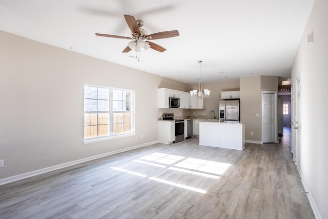 unfurnished living room with ceiling fan with notable chandelier, sink, and light hardwood / wood-style flooring