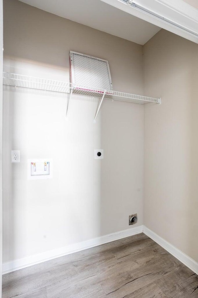 clothes washing area featuring wood-type flooring and hookup for an electric dryer