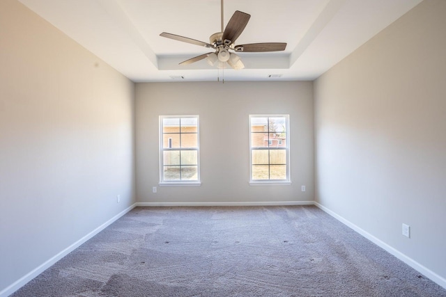 carpeted empty room featuring ceiling fan and a tray ceiling