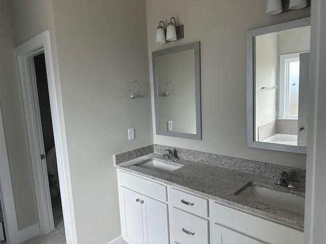 bathroom featuring a tub to relax in and vanity