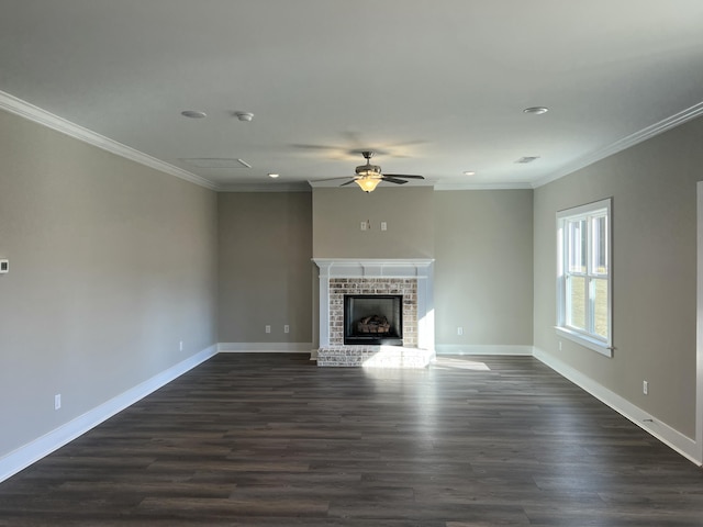 unfurnished living room featuring ceiling fan, ornamental molding, dark wood-type flooring, and a brick fireplace