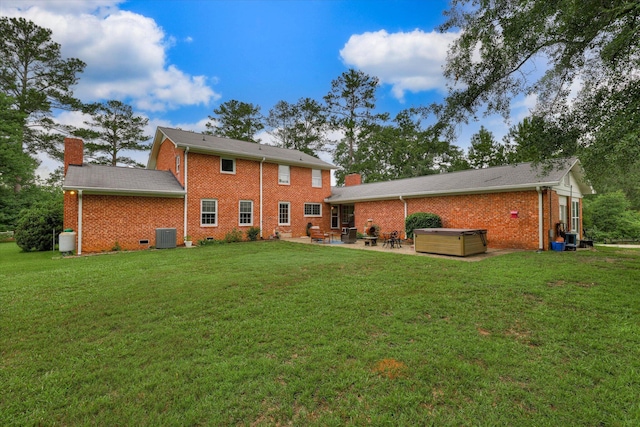 711 Augusta St, Mccormick, SC 29835 - back of property featuring a hot tub, a patio, a chimney, and brick siding