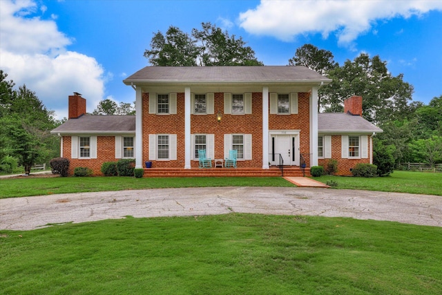 711 Augusta St, Mccormick, SC 29835 - neoclassical / greek revival house featuring a chimney, asphalt driveway, and brick siding