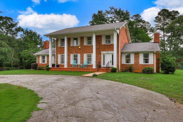 711 Augusta St, Mccormick, SC 29835 - greek revival inspired property with a chimney, brick siding, driveway, and a front yard