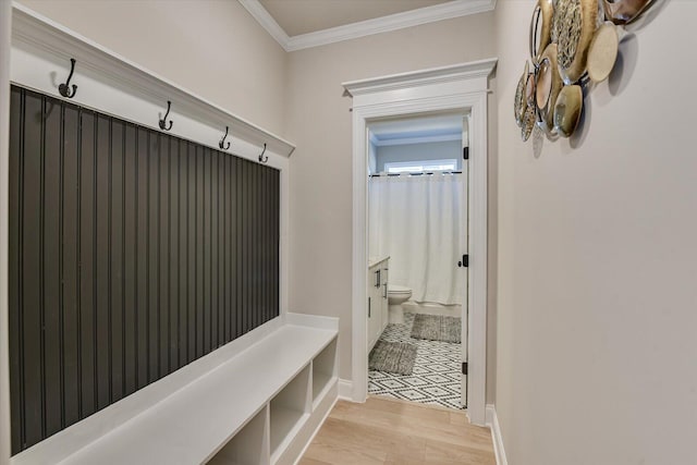 mudroom with ornamental molding, light wood-style flooring, and baseboards