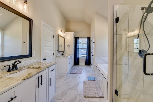 bathroom featuring a garden tub, lofted ceiling, two vanities, a sink, and a shower stall