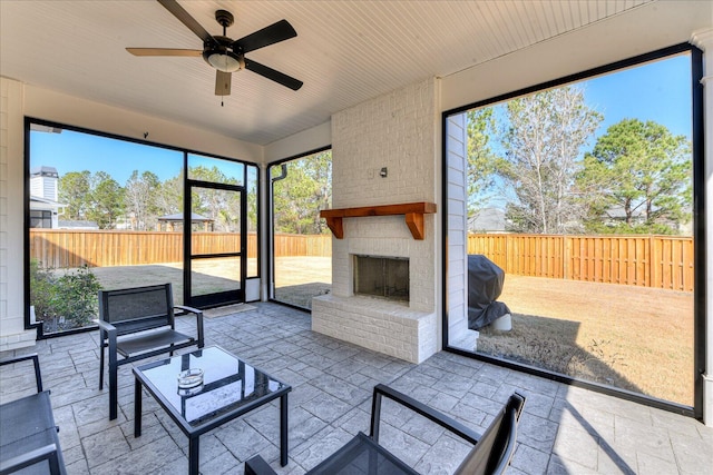 sunroom featuring an outdoor brick fireplace, wooden ceiling, and a ceiling fan