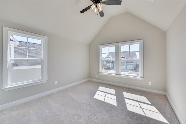 empty room featuring lofted ceiling, carpet flooring, and baseboards