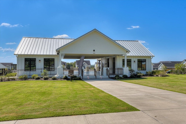 modern inspired farmhouse featuring metal roof, a front lawn, board and batten siding, and concrete driveway