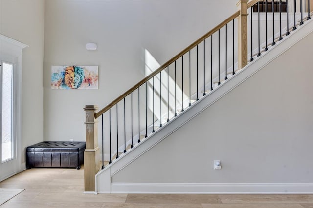 staircase featuring baseboards and wood finished floors