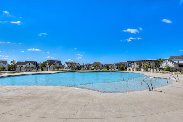 community pool featuring a patio area, a residential view, and a pergola