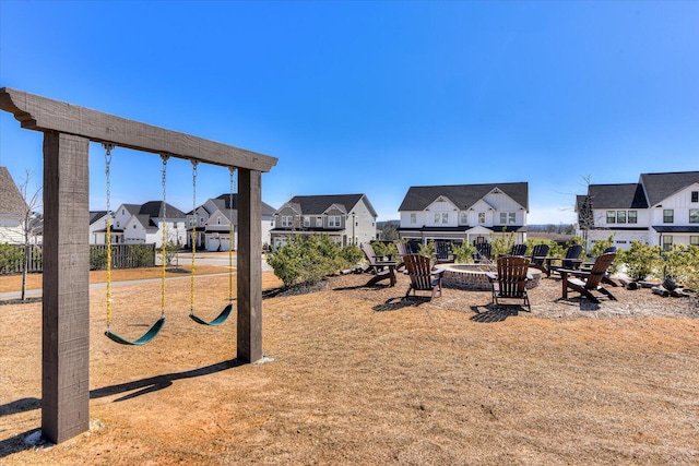 exterior space featuring playground community, an outdoor fire pit, and a residential view