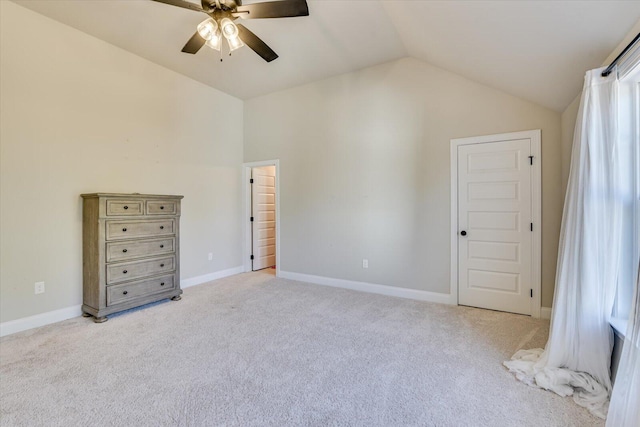 unfurnished bedroom featuring lofted ceiling, baseboards, a ceiling fan, and light colored carpet