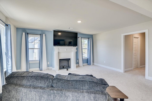 carpeted living room featuring a fireplace with flush hearth, recessed lighting, and baseboards