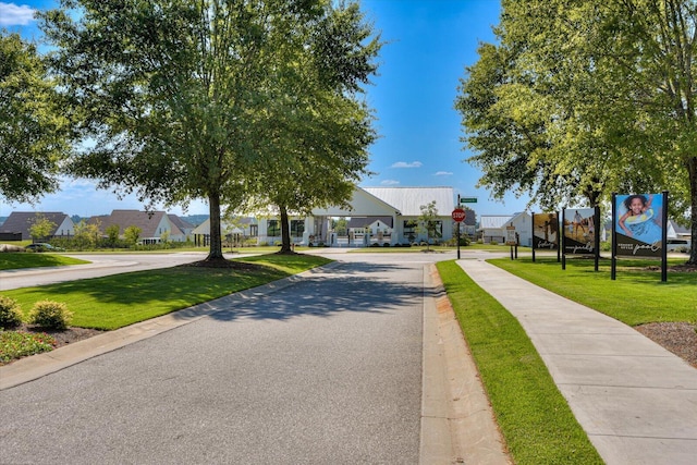 view of road featuring curbs, traffic signs, sidewalks, and a residential view