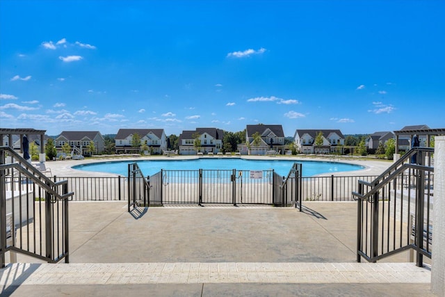 pool with a residential view, fence, and a patio