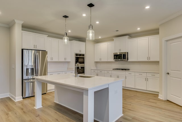 kitchen featuring light countertops, ornamental molding, appliances with stainless steel finishes, and a sink