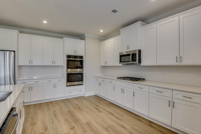 kitchen with visible vents, appliances with stainless steel finishes, crown molding, and light countertops