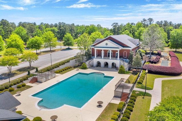 pool featuring a patio, stairs, and fence