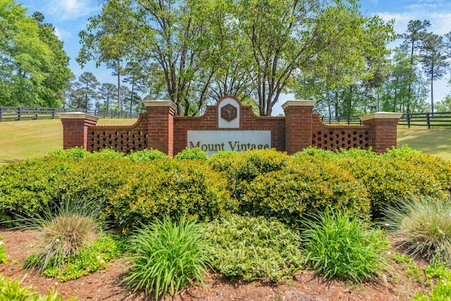 community sign with a yard and fence