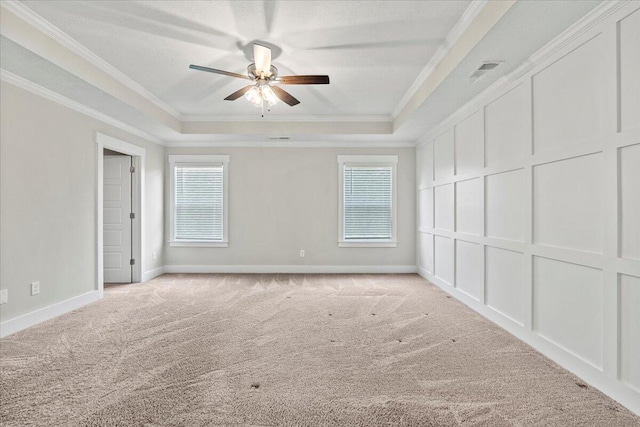 2318 Laurens St, Grovetown, GA 30813 - empty room featuring a raised ceiling, light carpet, a ceiling fan, ornamental molding, and healthy amount of natural light