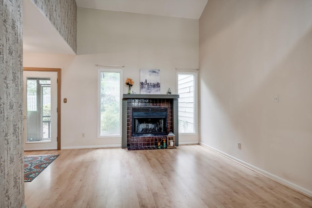20 Teal Ct, North Augusta, SC 29841 - living room with a tiled fireplace, baseboards, a high ceiling, and wood finished floors