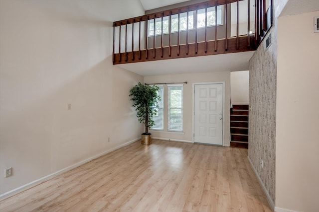 20 Teal Ct, North Augusta, SC 29841 - unfurnished living room featuring visible vents, a towering ceiling, wood finished floors, stairway, and baseboards