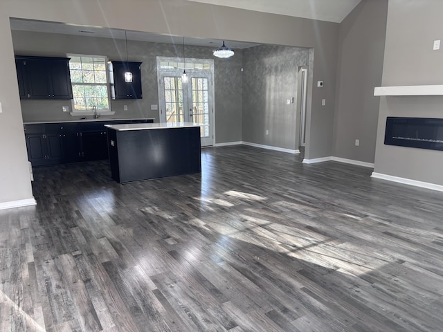 kitchen featuring french doors, a center island, light countertops, and dark wood-type flooring