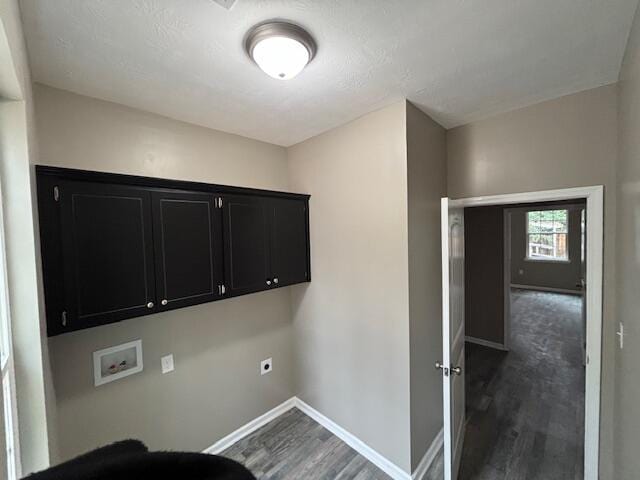 laundry area with dark wood finished floors, hookup for a washing machine, cabinet space, and baseboards