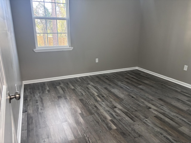 spare room with dark wood-style floors and baseboards