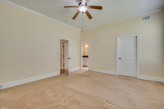 unfurnished bedroom featuring ceiling fan, light colored carpet, ornamental molding, and connected bathroom