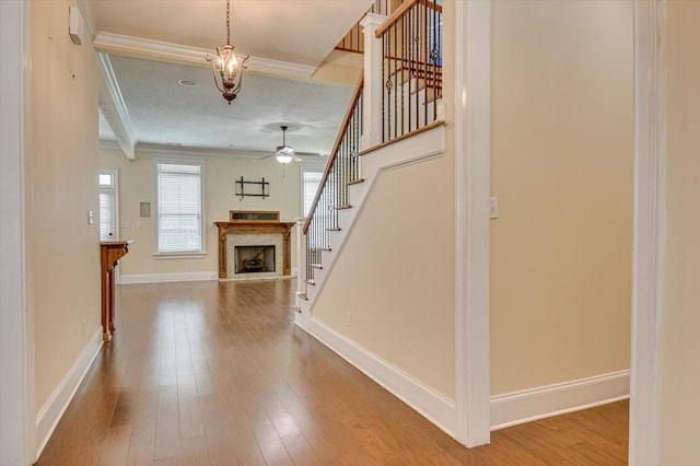 interior space featuring ceiling fan, crown molding, beamed ceiling, and wood-type flooring