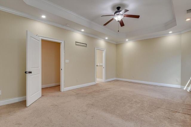 carpeted empty room with ceiling fan, ornamental molding, and a tray ceiling