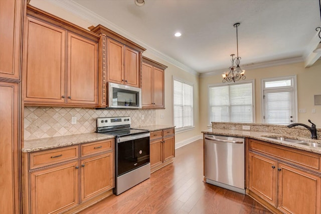 kitchen featuring sink, an inviting chandelier, light hardwood / wood-style flooring, decorative backsplash, and appliances with stainless steel finishes