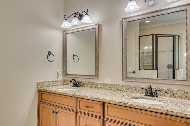 bathroom with vanity, a shower with door, and crown molding