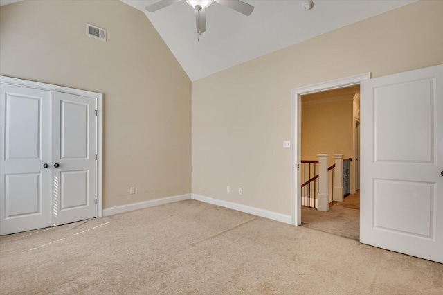 unfurnished bedroom with ceiling fan, a closet, light carpet, and lofted ceiling