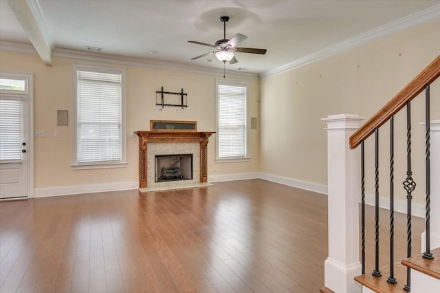 unfurnished living room featuring hardwood / wood-style floors, ceiling fan, ornamental molding, and a premium fireplace