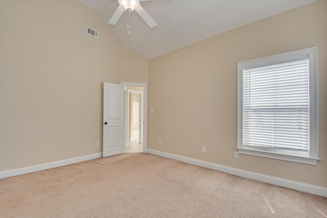 spare room featuring light carpet, vaulted ceiling, and ceiling fan