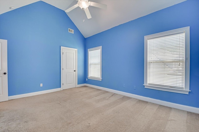 carpeted spare room with ceiling fan and lofted ceiling